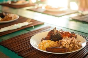 珀拉什奇亚Ranguana Caye Cabanas的餐桌上一盘带肉和米饭的食物