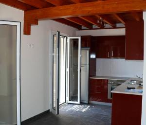 瓦西利基Casa Nostos的一间带木制天花板的厨房和一间带冰箱的厨房