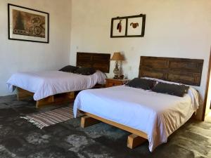 瓦曼特拉Hacienda Santa Barbara Casa Malinche的一间卧室配有两张床和一张带台灯的桌子
