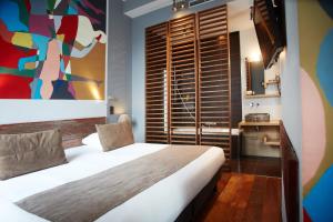 布鲁塞尔圣特格雷精品酒店的卧室配有一张床,墙上挂有绘画作品