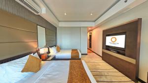 科伦坡科伦坡桔子酒店的配有一张床和一台平面电视的酒店客房