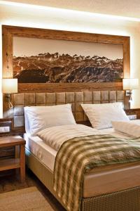菲伯布伦阿尔特伯斯特酒店的一间卧室设有两张床,墙上挂着一幅画