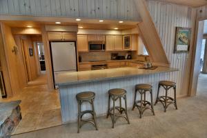 CableSerenity On Lake Owen Condo的厨房配有四把吧台凳和台面
