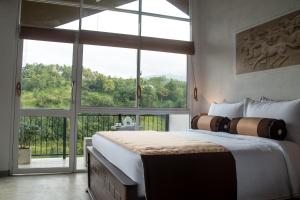 康提Kandy Victoria Eco Resort的一间卧室设有一张大床和一个大窗户