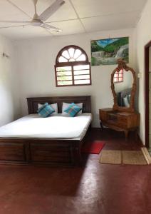 希克杜沃Raj Villa Kumarakanda Hikkaduwa的一间卧室配有一张大床和镜子