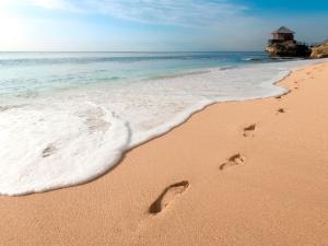 金巴兰RIMBA by AYANA Bali的沙滩上的一对脚印