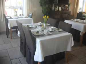 格朗当金宝别墅的一间用餐室,配有2张带白色桌布的桌子