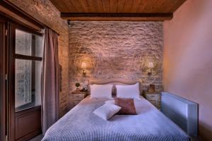 尼奥·奥伊蒂龙派特拉及福斯精品温泉酒店的一间卧室设有一张床和石墙