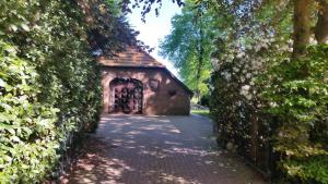韦斯特尔斯特德Ferienwohnung Kaminzimmer的石屋入口,有树 ⁇ 