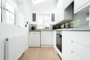 牛津The Old Tailor House - Charming 4BDR Home的厨房配有白色橱柜和白色家电