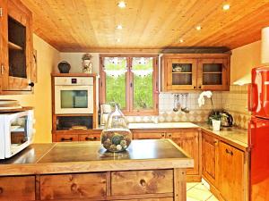 Le Villard罗莎苇酒店的厨房配有木制橱柜和红色冰箱。