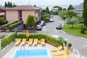 巴多利诺Hotel GARDENIA & Villa CHARME Adults Friendly 10Plus的一个带游泳池、椅子和停车场的酒店