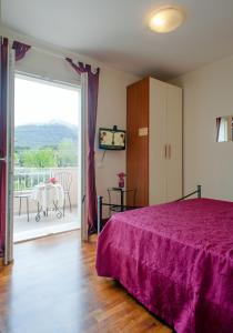 蒙蒂尼奥索阿尔特里玫瑰住宿加早餐酒店的一间卧室配有一张带紫色床罩的床