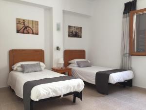 卡拉米洛Sol y Luna Cala Millor的白色墙壁客房的两张床