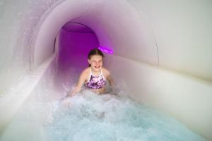 伊马特拉依玛卡布拉芬兰地亚水疗酒店的紫色水滑梯的小女孩