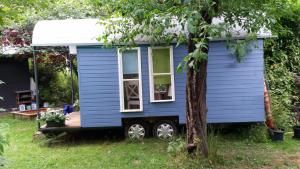卡塞尔Schaferwagen的停在树旁的蓝色小房子