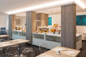 里米尼阿索托丽亚套房酒店的一间设有桌子和书架的餐厅,展示着食物