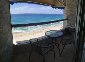 巴特亚姆Apart Hotel TLV/Bat Yam Beach Front 1207的客房可从窗户欣赏到海滩美景