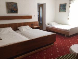 吕德斯海姆咖啡博斯特酒店的一间卧室配有两张床,铺有红地毯