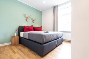 弗莱堡Freiburg Apartments Friedrichring的一间卧室配有一张带红色枕头的大床