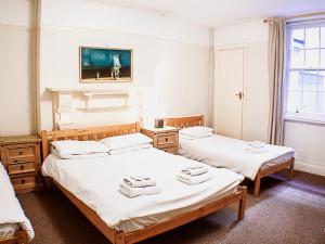 布莱顿霍夫奎恩斯伯里酒店的一间设有两张床铺和毛巾的房间