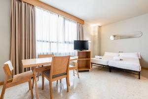 莱昂圣马梅斯埃克园公寓式酒店的酒店客房设有餐桌和床。