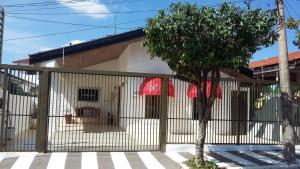 巴乌鲁Casa Beatles Hostel Bauru的前面有树的围栏的房子