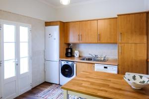 塔维拉Casa Séqua的厨房配有木制橱柜、洗衣机和烘干机