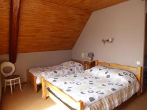 Saint-Julien-en-Champsaur莱斯柴纳茨酒店的一间卧室设有两张床和木制天花板