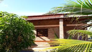 日若卡-迪热里科阿科阿拉Recanto Vendramel Bezerra的一个小砖房子,有窗户和一些树木