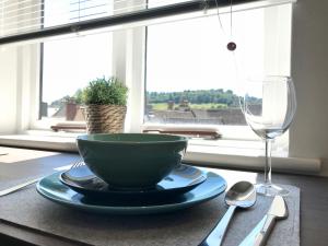 斯特劳德Upper Highview - Self Catering Apartment, fpventures Stroud的一张桌子,上面放着碗和一杯葡萄酒