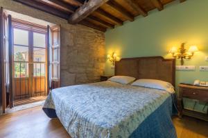 圣地亚哥－德孔波斯特拉Asador de Roxos Casa Albardonedo的一间卧室设有一张床和一个大窗户