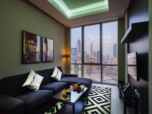 科威特Saray Prime Suites的带沙发和大窗户的客厅