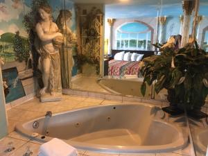 加洛韦Deluxe Inn的带浴缸的浴室和卧室