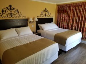 萨默赛德Sunny Isle Motel的酒店客房设有两张床和窗户。