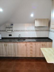 里瓦德奥Apartamento Apega的一个带木制橱柜和水槽的厨房