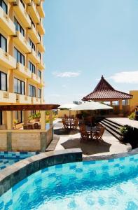 三宝垄帕恩达昂恩酒店的一个带桌子和遮阳伞的酒店游泳池