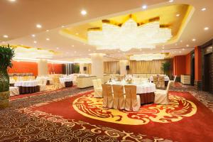 北京北京日坛宾馆的宴会厅配有白色的桌椅和吊灯