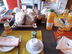 Cercy-la-Tour切兹玛丽酒店的桌子上放有盘子和瓶橙汁