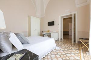 卡萨拉诺Palazzo Fasti的白色卧室配有床和桌子