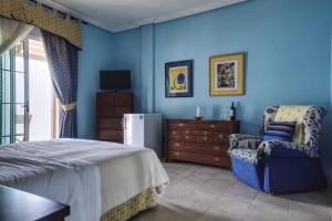 莫罗德哈布雷Hotel La Colina的卧室拥有蓝色的墙壁,配有一张床和椅子