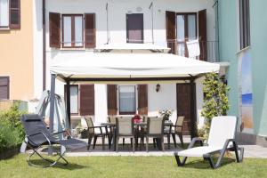 阿罗纳La Casa di Cristina的庭院配有桌椅和遮阳伞。