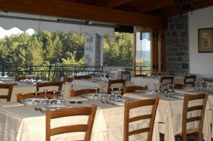 卡普雷塞·米开朗基罗Buca di Michelangelo的餐厅设有白色的桌椅和大窗户