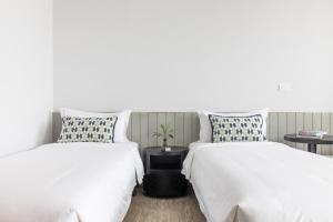曼谷家图亚公寓酒店的两张睡床彼此相邻,位于一个房间里
