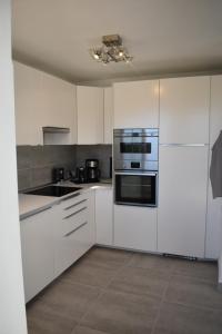 塔科龙特Komfort Wellness Haus Mesa del Mar的厨房配有白色橱柜和炉灶烤箱。