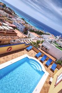 莫罗德哈布雷Hotel La Colina的一个带椅子的游泳池,背景是大海