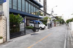 曼谷家图亚公寓酒店的停在大楼前的一条空的街道,有一辆白色的货车