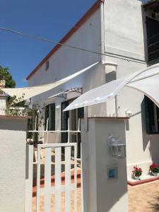 巴勒莫Mondello Home "46 passi"的白色的房子,配有白色的围栏和雨伞