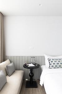 曼谷家图亚公寓酒店的配有床、桌子和沙发的房间
