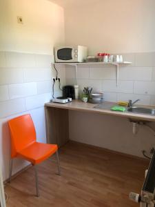 不莱梅Rana's Zimmervermittlung 2的厨房配有橙色椅子和水槽